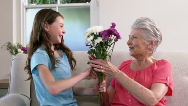 Chica sorprendiendo a su abuela con flores — Vídeos de Stock