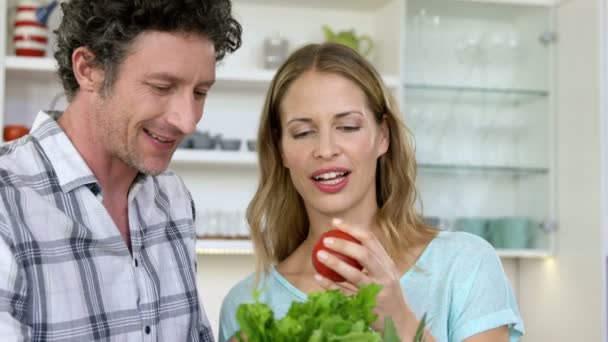 Улыбающаяся пара держит помидор — стоковое видео