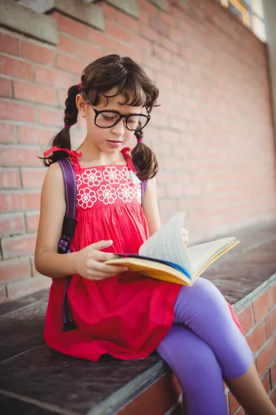 Flicka som läser en bok utanför — Stockfoto