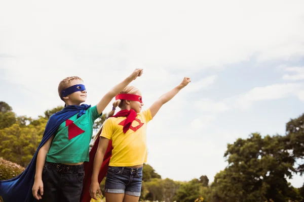 Kinderen met superheld jurk poseren met opgeheven arm — Stockfoto