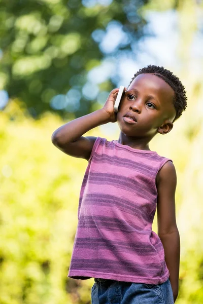 Un enfant reçoit un appel téléphonique. — Photo