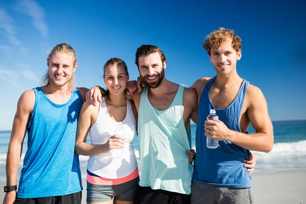 Smiling friends standing at the beach — Stock Photo, Image