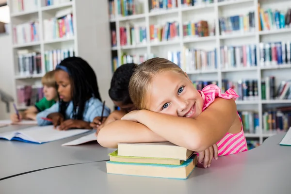 Kleines Mädchen posiert mit verschränktem Arm am Schreibtisch — Stockfoto