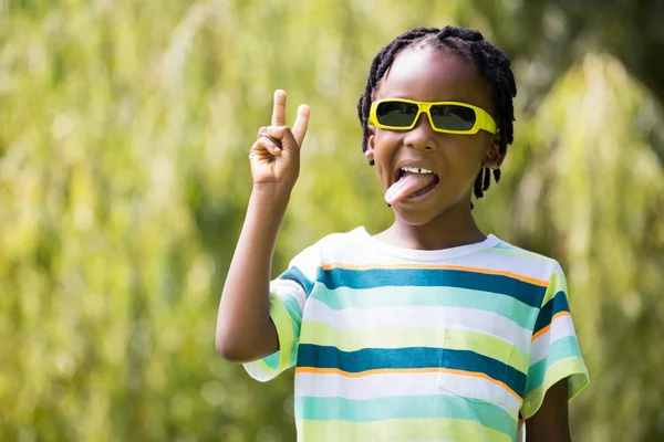 A kid with sunglasses making faces — Stock Photo, Image