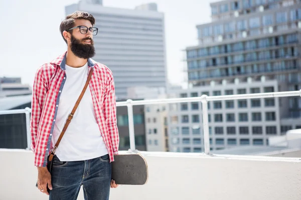 Hipster άνθρωπος που κρατά skateboard του — Φωτογραφία Αρχείου