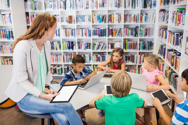 Jonge mooie leraar hebben les aan kinderen met hun tafel — Stockfoto