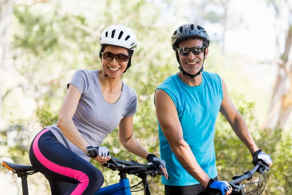 Casal sorrindo e posando com suas bicicletas — Fotografia de Stock