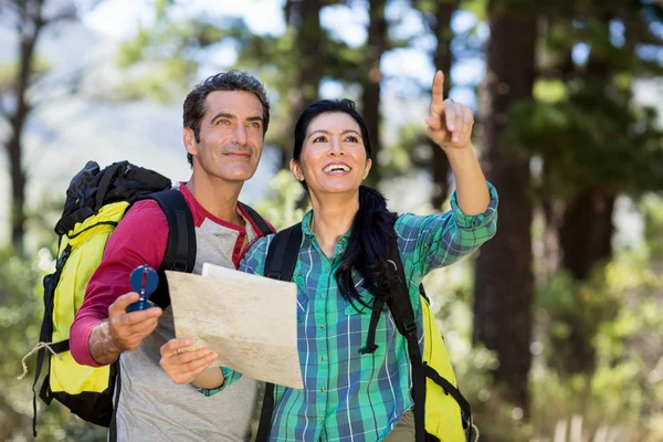 Casal apontando e segurando um mapa — Fotografia de Stock