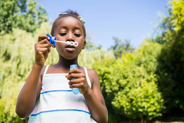 Leuk gemengd ras meisje glimlachend en spelen met bubbels — Stockfoto