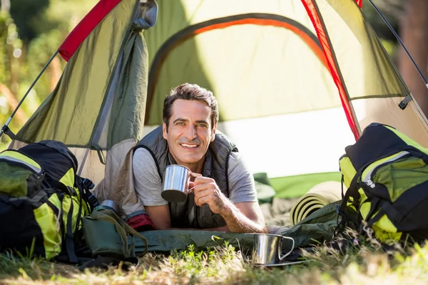 Man laying and holding cup — Stock Photo, Image