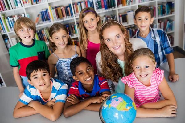 Enseignant et élèves posant avec globe — Photo