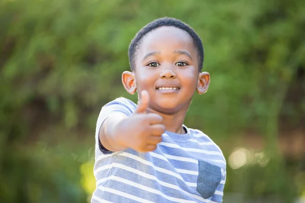 Portrait of cute boy smiling with thumbs up — Stockfoto