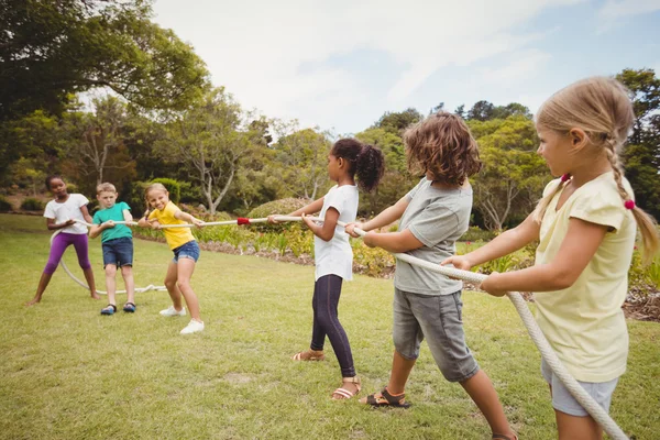 Niños sonriendo y jugando con una cuerda — Foto de Stock