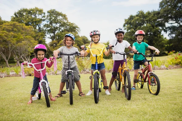 Bambini felici che indossano il casco e posano sulla loro moto — Foto Stock