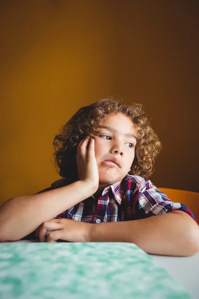 Boy sitting down on his chair and dreaming — Stock Photo, Image