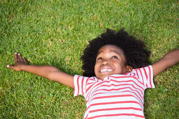 Sonriente niño acostado en la hierba — Foto de Stock