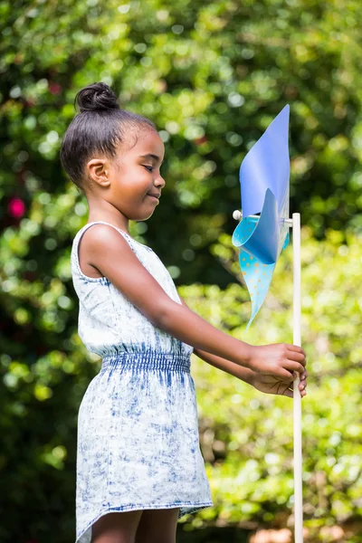 Niña sosteniendo un molinete en el parque —  Fotos de Stock