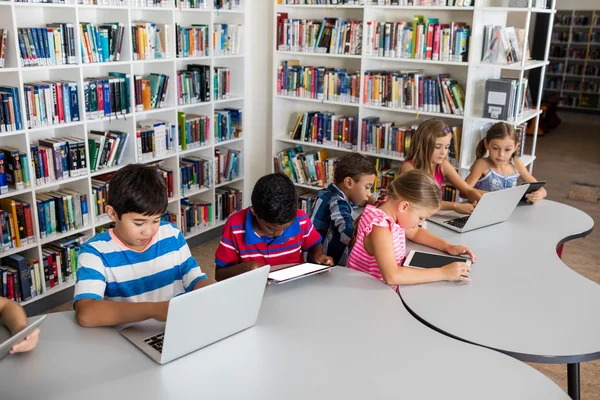 Zijaanzicht van de leerling met laptop en tablet pc — Stockfoto