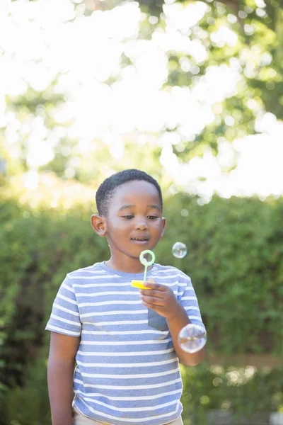 Портрет мальчика, делающего пузыри с помощью палочки — стоковое фото