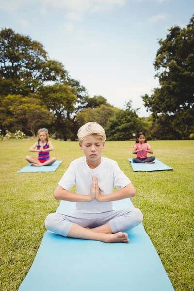 Ritratto di un ragazzo che fa yoga con altri bambini — Foto Stock