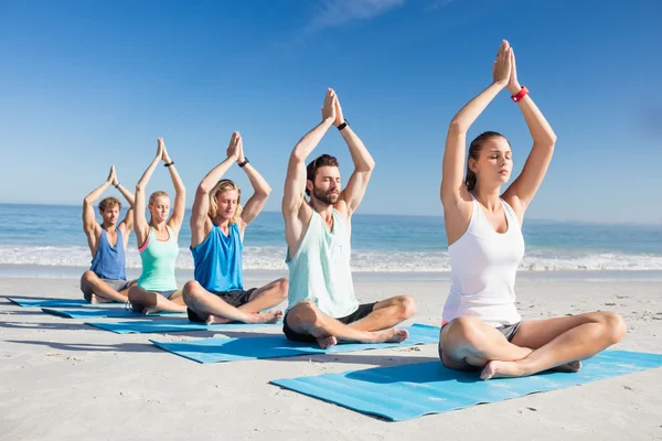 Människor som gör yoga på stranden — Stockfoto