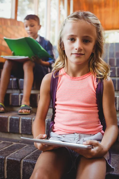 Cute little schoolgirl with her digital tablet — Stock Photo, Image