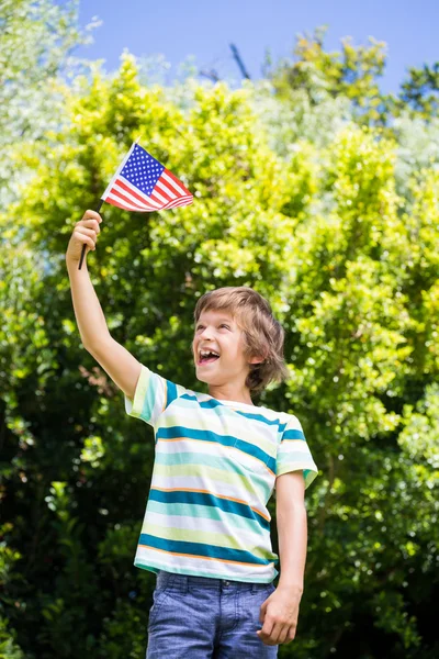 Um menino está segurando uma bandeira americana — Fotografia de Stock