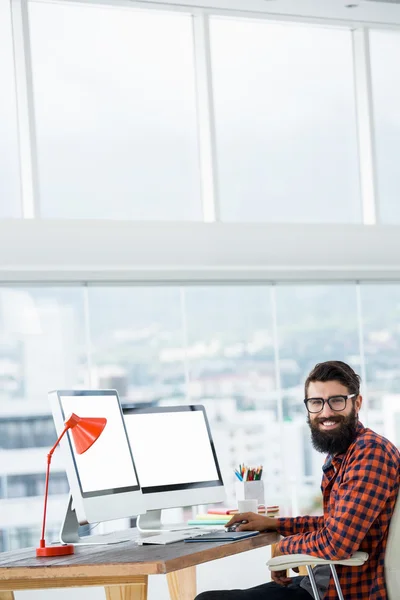 Hipster sitting in front of a computer — Stock Photo, Image