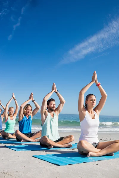 Människor som gör yoga på stranden — Stockfoto