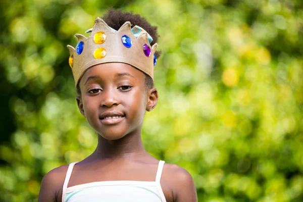 Retrato de uma menina de raça mista sorrindo e vestindo uma coroa — Fotografia de Stock