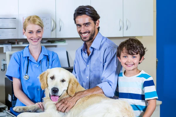 Mujer veterinaria y dueños de perros sonriendo y posando — Foto de Stock