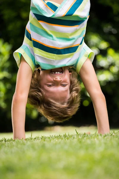 Ein kleiner Junge spielt kopfüber — Stockfoto