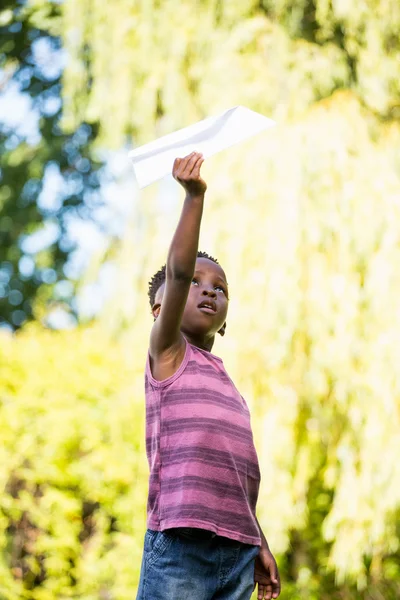 Cute mixed-race boy playing with a paper plane — Stock Photo, Image