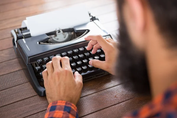 Un hombre está escribiendo en un tipo escritor —  Fotos de Stock