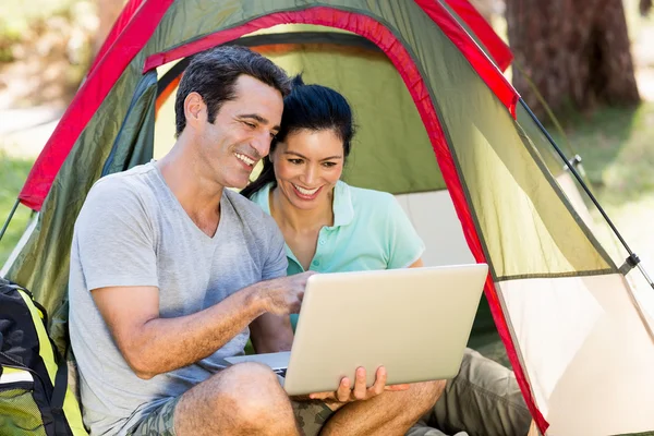 Casal sorrindo e usando um laptop — Fotografia de Stock