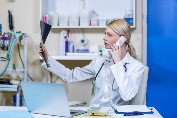 Uma mulher veterinária olhando raio-x e chamando — Fotografia de Stock