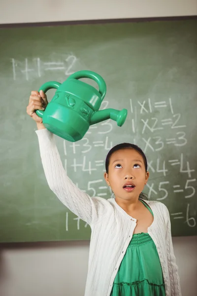 Schoolgirl using a watering can — Stock Photo, Image