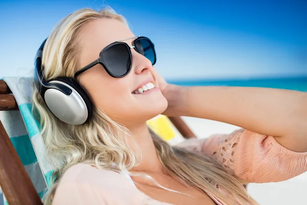 Mujer escuchando música a través de auriculares —  Fotos de Stock