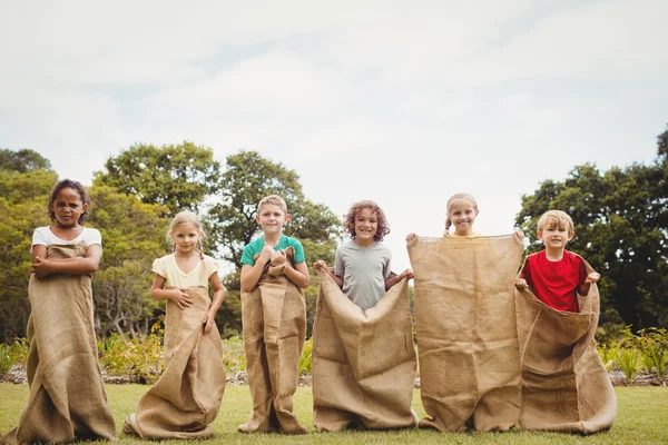 Children smiling and posing inside bag — Stock Photo, Image