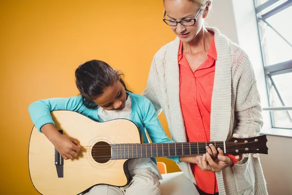 Dziewczyna, uczy się grać na gitarze — Zdjęcie stockowe