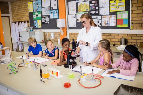 Teacher giving lesson to her students — Stock Photo, Image