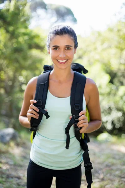 Kvinnan ler och poserar med en ryggsäck — Stockfoto