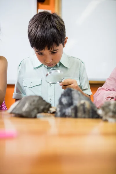 Niños mirando fósiles con una lupa —  Fotos de Stock