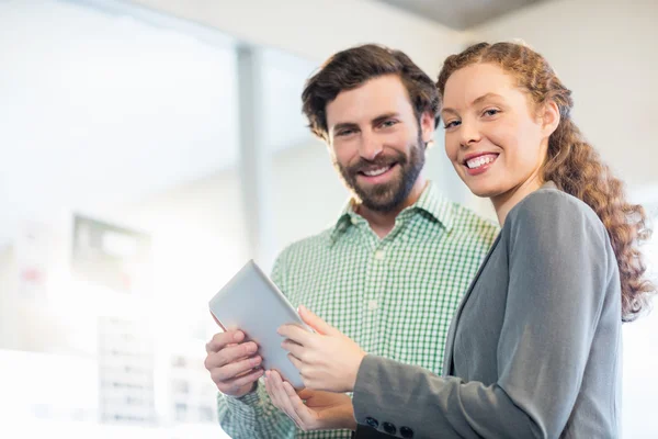 Zakenman en zakenvrouw bespreken met behulp van digitale tablet — Stockfoto