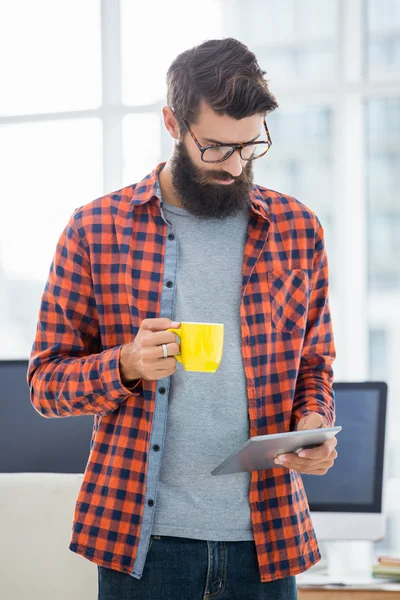 Hipster using tablet and drinking coffee — Stock Photo, Image
