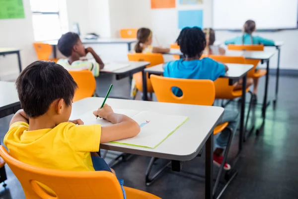 Alunos trabalhando em sua mesa em classe — Fotografia de Stock