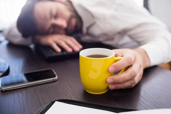 Schlafender Geschäftsmann mit Tasse in der Hand — Stockfoto