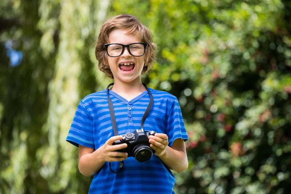 Lindo chico con gafas sosteniendo una cámara — Foto de Stock