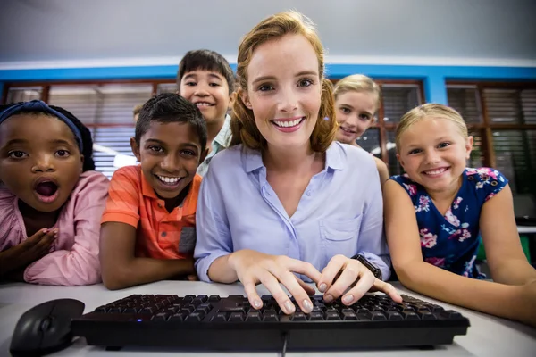 Professora dando lição aos seus alunos com tecnologia — Fotografia de Stock