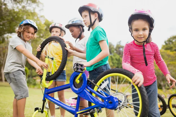 Niños usando casco y tocando bicicleta —  Fotos de Stock